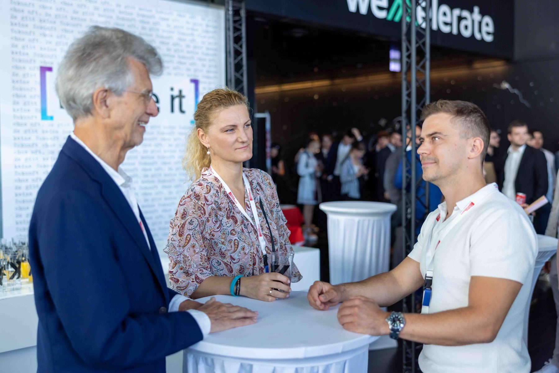 Gergely Romhány in conversation with two people at a startup event